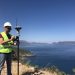 Geodetic engineer surveyor in white hard hat doing measurements with GNSS satellite receiver
