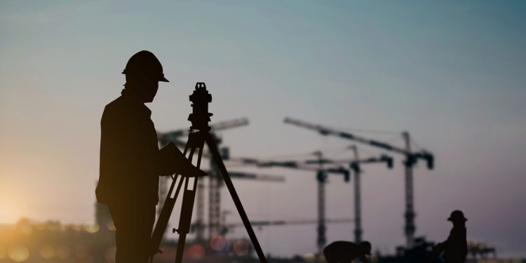 silhouette engineer looking Loaders and trucks in a building site over Blurred construction worker on construction site