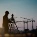 silhouette engineer looking Loaders and trucks in a building site over Blurred construction worker on construction site