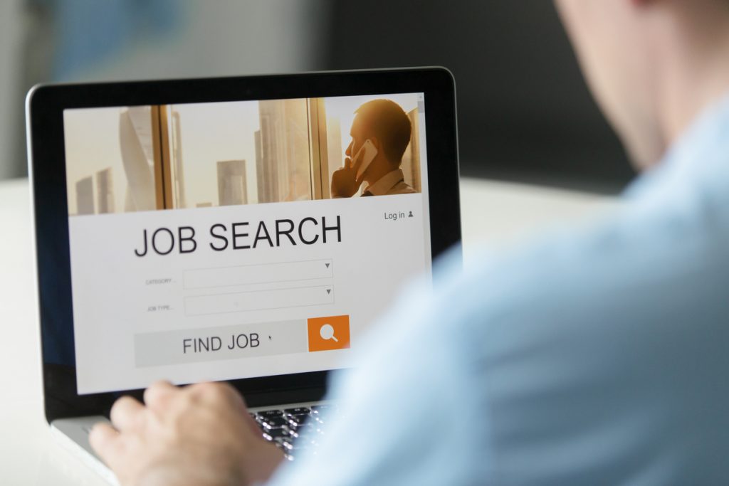 Monitor view over a male shoulder, job search title