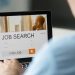 Monitor view over a male shoulder, job search title
