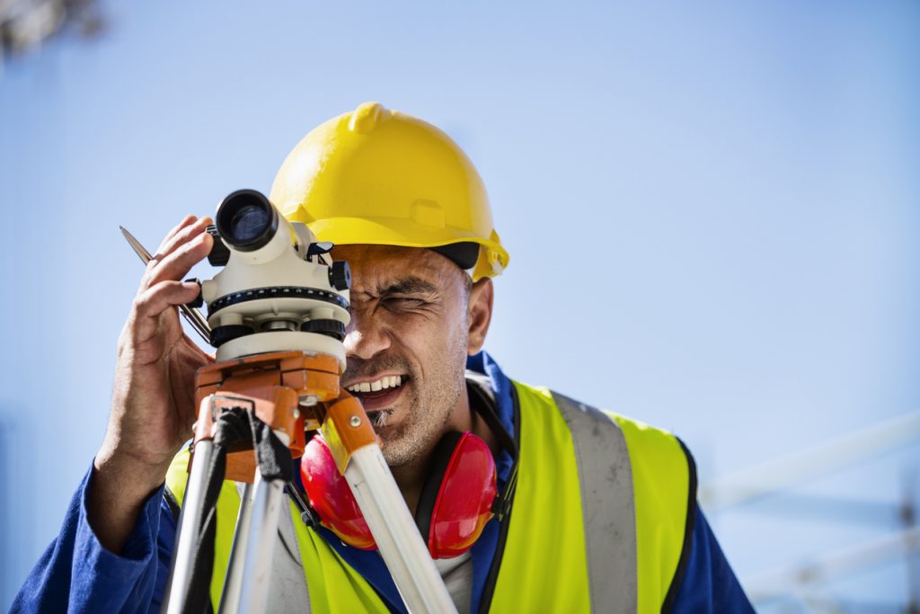 Architect examining site through theodolite