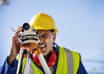 Architect examining site through theodolite