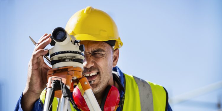 Architect examining site through theodolite