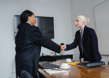 Free Cheerful colleagues shaking hands in office Stock Photo